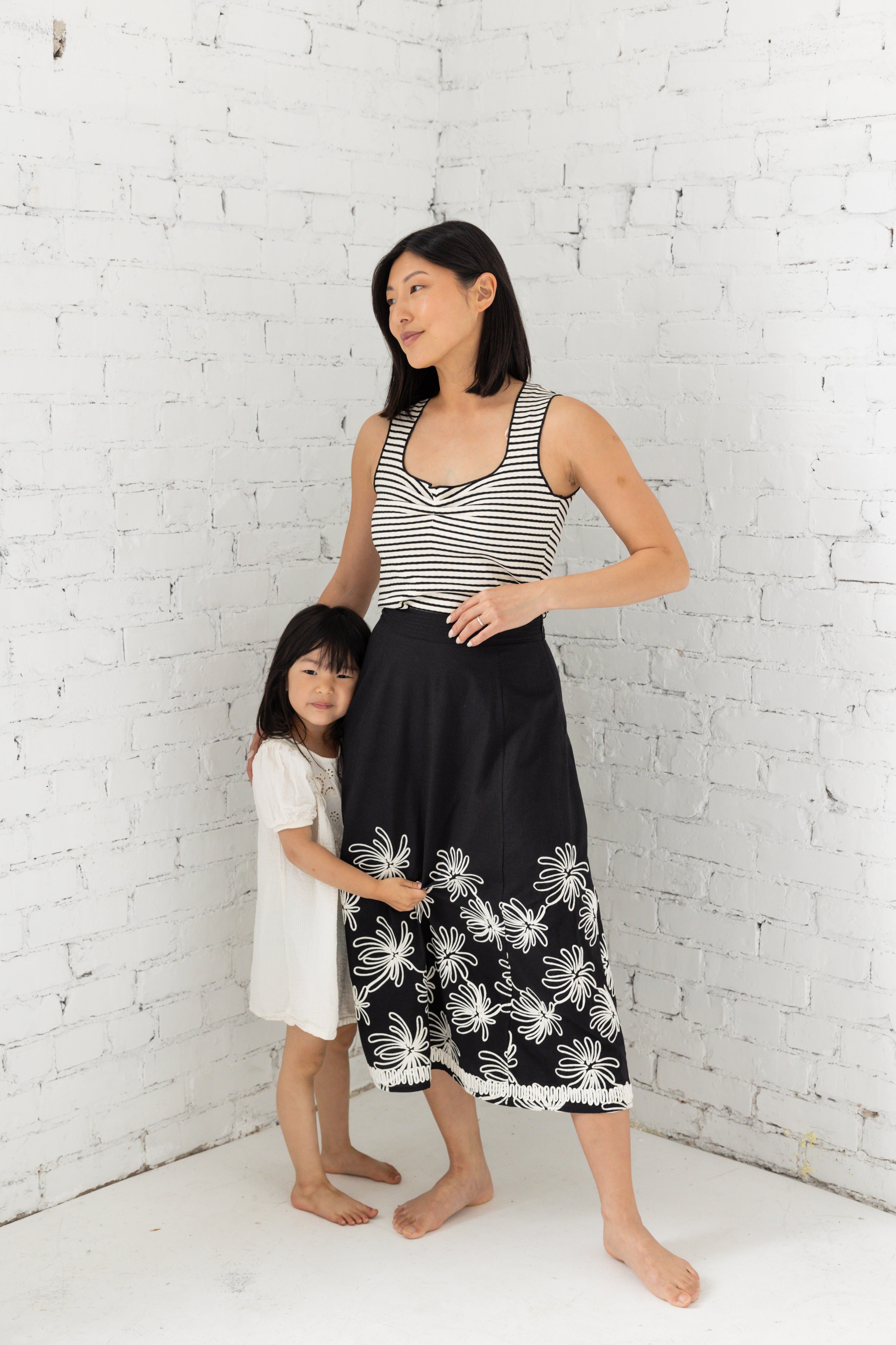 Model is wearing a striped tank top with sweetheart neckline with her children. 