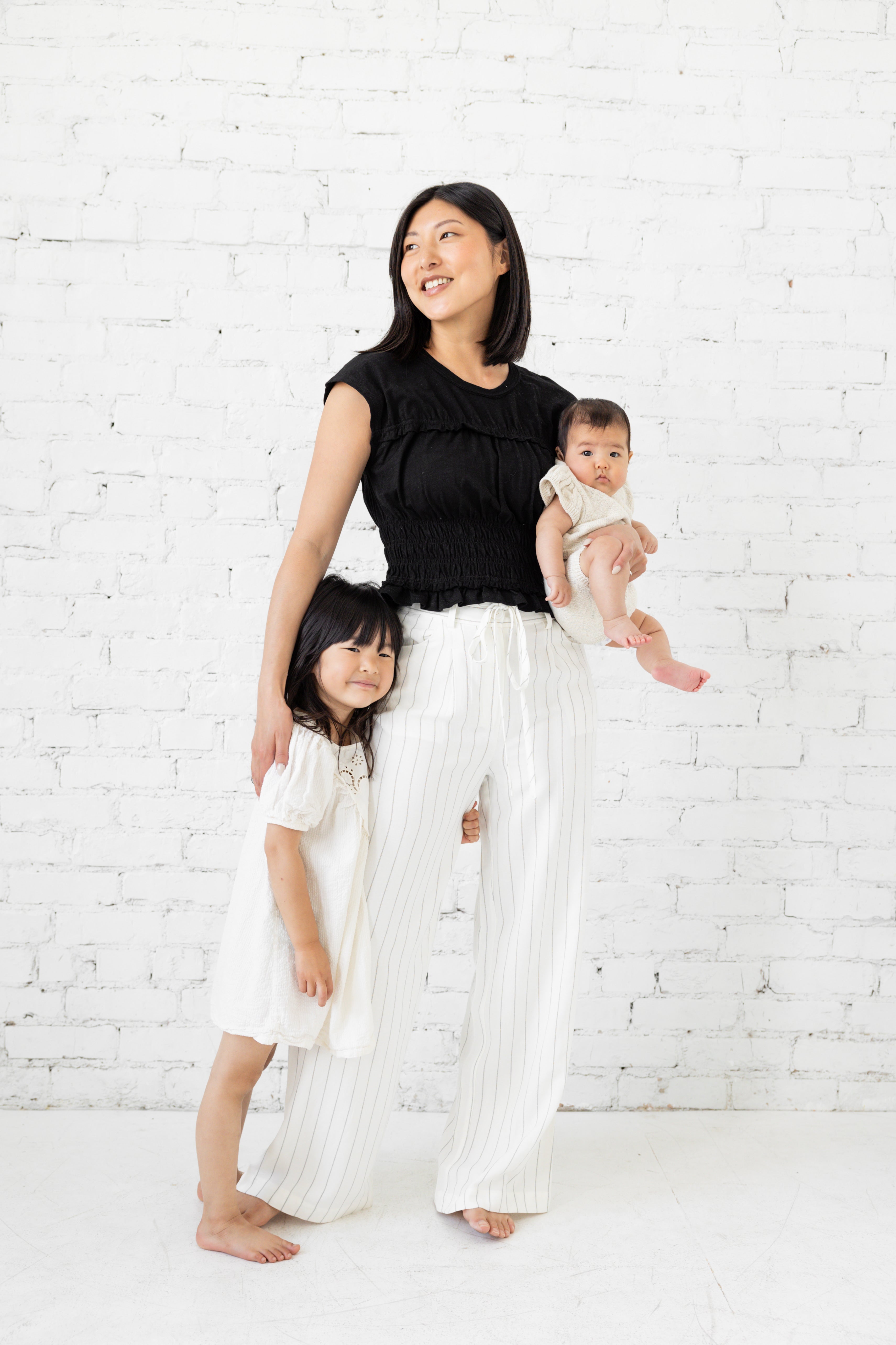 Model is wearing a white striped pant with tie waist belt. 
