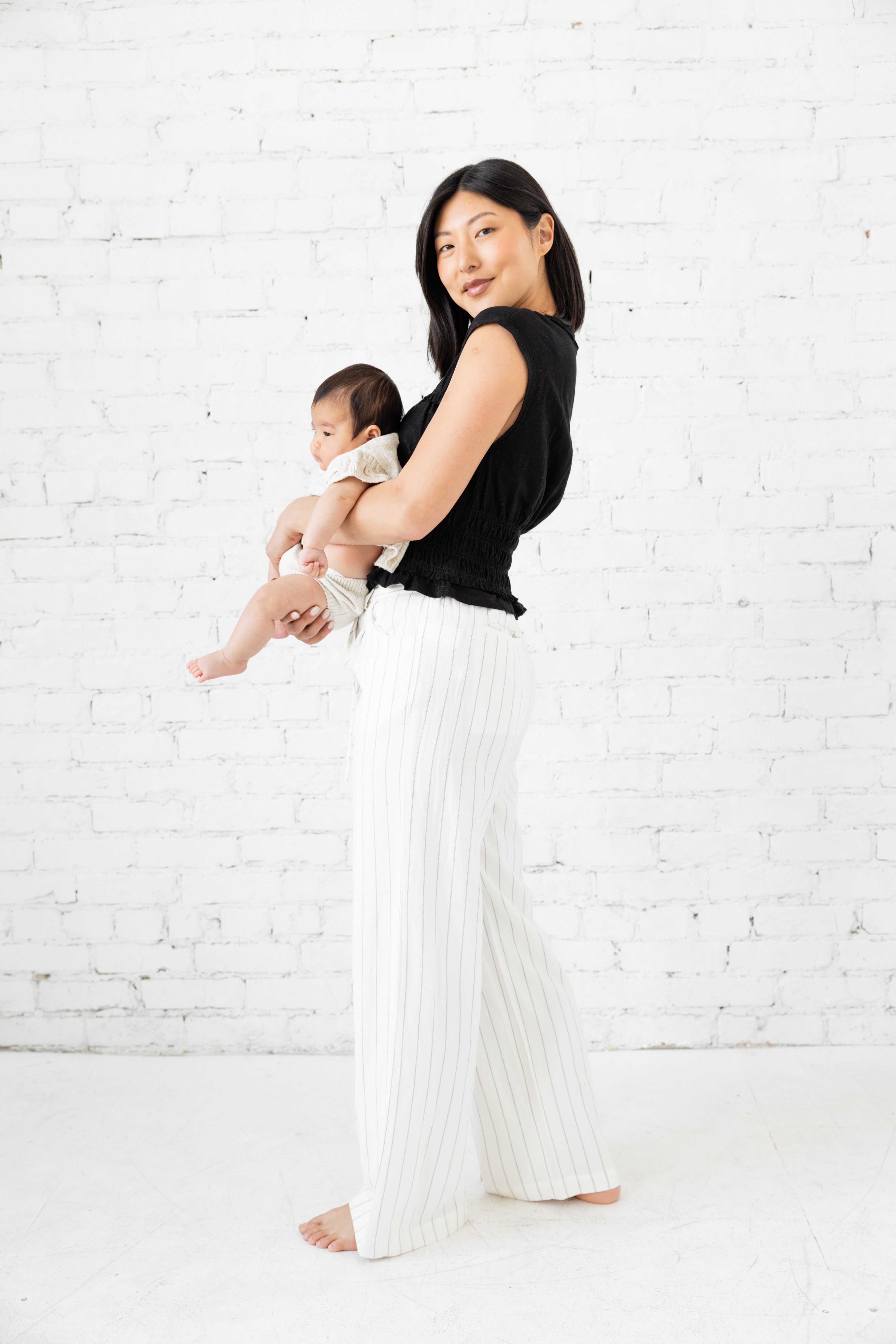 Model is wearing a white striped pant with tie waist belt. 